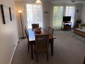 a dining room table and chairs in a living room at Beach Haven Villa in North Haven +6 photos