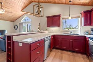 a kitchen with red cabinets and a sink at Upper Deck by Simple Life Rentals in Sturgeon Bay