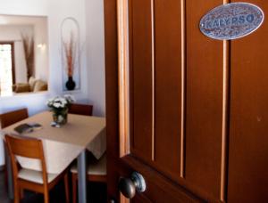 a room with a table and a door with a sign on it at Apartment Kalypso in Agia Anna Naxos