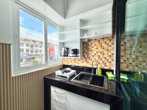 a kitchen with a sink and a window at Chalong - Studio Service Apartment - Phoomjai in Ban Klang