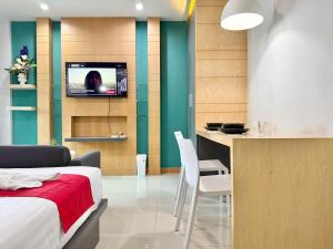 a bedroom with a bed and a kitchen with a table at Chalong - Studio Service Apartment - Phoomjai in Ban Klang