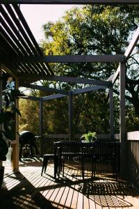 a bench sitting on a deck with a pergola at The Angle House - Aireys Inlet in Aireys Inlet +12 photos