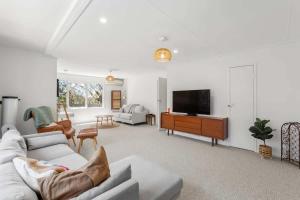 a living room with a couch and a tv at Sunny Coastal Retreat in Anglesea