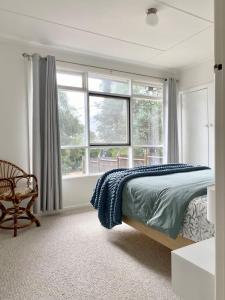 a bedroom with a bed and a large window at Sunny Coastal Retreat in Anglesea