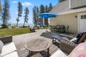 a wooden deck with chairs and an umbrella at Tranquility Bay Getaway by Simple Life Rentals in Sister Bay