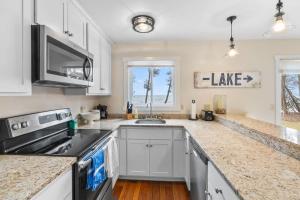 a kitchen with white cabinets and a stove top oven at Tranquility Bay Getaway by Simple Life Rentals in Sister Bay +16 photos