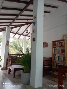 a living room with a table and a book shelf at The Ritz Hikkaduwa in Hikkaduwa