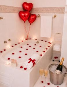 a bath tub filled with hearts and a bottle of champagne at Pousada Jupter in Teresópolis +143 photos