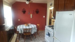a kitchen with a table and a white refrigerator at The Sparkle House in Cedar Rapids