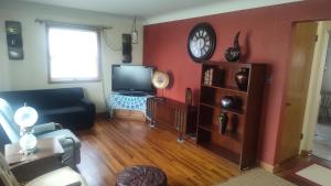 a living room with a couch and a clock on the wall at The Sparkle House in Cedar Rapids