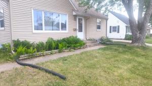 a house with a hose coming out of a yard at The Sparkle House in Cedar Rapids