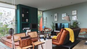 a living room with a couch and chairs and a tv at Keam House in Santana