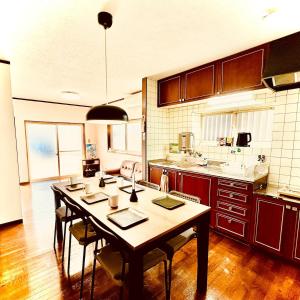 a kitchen with a table and chairs in a room at Between Kyoto & Osaka 渚南 駅徒歩3分 in Hirakata