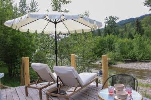 a patio with two chairs and an umbrella at Woodland Creek in Chase