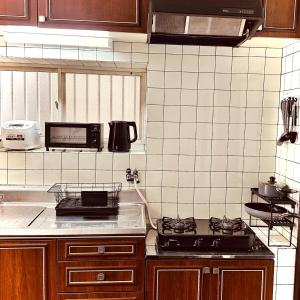 a kitchen with a stove and a counter top at Between Kyoto & Osaka 渚南 駅徒歩3分 in Hirakata