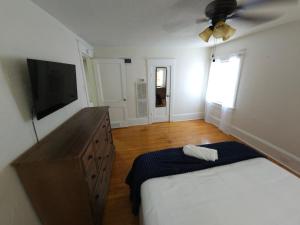 a bedroom with a bed and a flat screen tv at Huge 4-Bedroom Historic Home & Game Room in Goldsboro