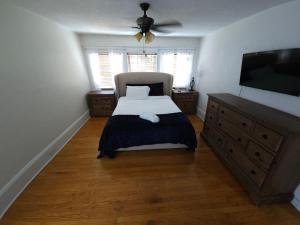 a bedroom with a bed and a flat screen tv at Huge 4-Bedroom Historic Home & Game Room in Goldsboro
