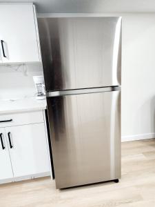 a stainless steel refrigerator in a kitchen with white cabinets at Edmonton Basement 1 KB 1 SB 3 Guest in Edmonton