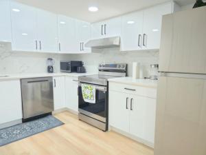 a white kitchen with white cabinets and appliances at Edmonton Basement 1 KB 1 SB 3 Guest in Edmonton
