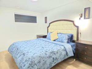 a bedroom with a bed with a blue comforter at Edmonton Basement 1 KB 1 SB 3 Guest in Edmonton