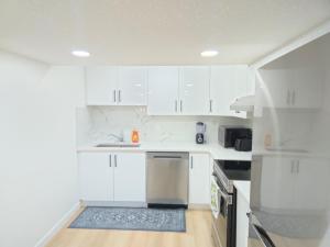 a kitchen with white cabinets and a stainless steel refrigerator at Edmonton Basement 1 KB 1 SB 3 Guest in Edmonton +40 photos