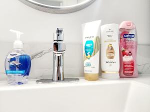 a shelf with bottles of bathroom products on it at Edmonton Basement 1 KB 1 SB 3 Guest in Edmonton