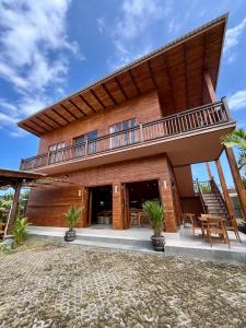 a large house with a balcony on top of it at Wavedance Bali Surfhouse in Airsatang