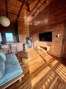a living room with a couch and a flat screen tv at Wavedance Bali Surfhouse in Airsatang