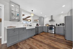 a kitchen with gray cabinets and wooden floors at High Garden by Simple Life Rentals in Sister Bay