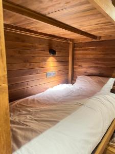 a bed in a room with a wooden wall at Wavedance Bali Surfhouse in Airsatang