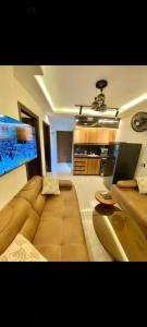 a living room with a large couch and a kitchen at بورتو جولف in El Dab‘a