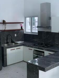 a kitchen with white cabinets and a sink at Comoda y hermosa casa MINDY in Tuxpan de Rodríguez Cano +12 photos