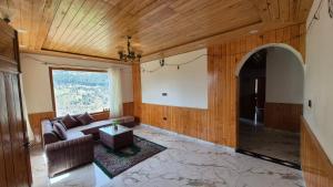 a living room with a couch and a window at Ivory Nest Villa in Chamba