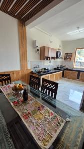 a large kitchen with a glass table with chairs at Ivory Nest Villa in Chamba