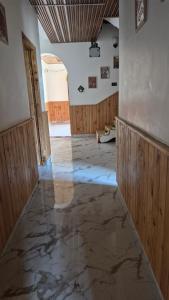 an empty room with a marble floor and wooden walls at Ivory Nest Villa in Chamba