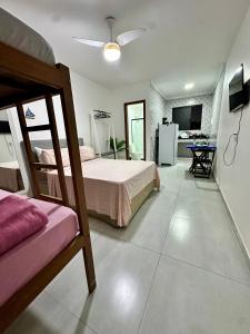 a bedroom with a bed and a living room at Âncora Lofts in Arraial do Cabo