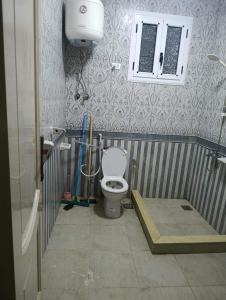 a bathroom with a toilet and a window in it at Holiday apartment in ‘Izbat al Waqf