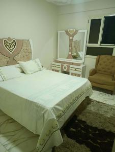 a bedroom with a large bed and a chair at Holiday apartment in ‘Izbat al Waqf