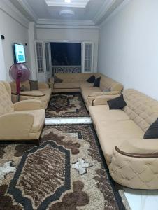 a living room with a large couch and a television at Holiday apartment in ‘Izbat al Waqf