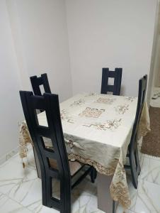 a table and two chairs with a white table cloth on it at Holiday apartment in ‘Izbat al Waqf