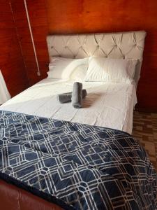 a bed with a blue and white blanket and pillows at Casa Versatil in Chuí