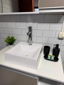 a white sink in a white counter top at Casa Versatil in Chuí