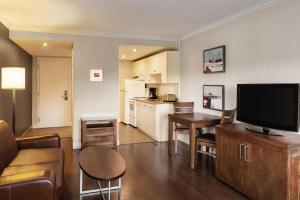 ein Wohnzimmer mit Fernseher und eine Küche in der Unterkunft Atlantic Host Hotel, an Ascend Collection Hotel in Bathurst