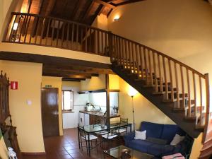 sala de estar con sofá azul y escalera en El Bulin de Horcajuelo, en Horcajuelo de la Sierra