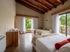 a bedroom with two beds and a window at Posada del Blanco in Potrerillos +96 photos