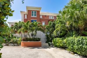 a house with palm trees in front of a driveway at Villa La Percha in Providenciales