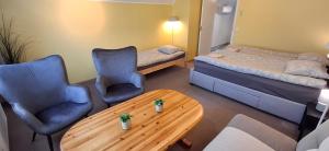 a room with two beds and a table and chairs at Sinilille 5 Holiday Home in Kuressaare