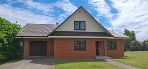 a house with a gambrel roof and a garage at Sinilille 5 Holiday Home in Kuressaare