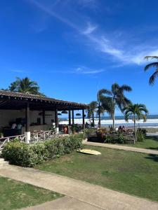 a restaurant on the beach with palm trees and the ocean at Resort Casita in Playa Venao +6 photos