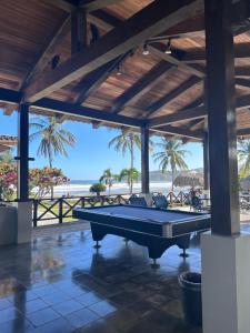 a pool table in a pavilion with the beach in the background at Resort Casita in Playa Venao
